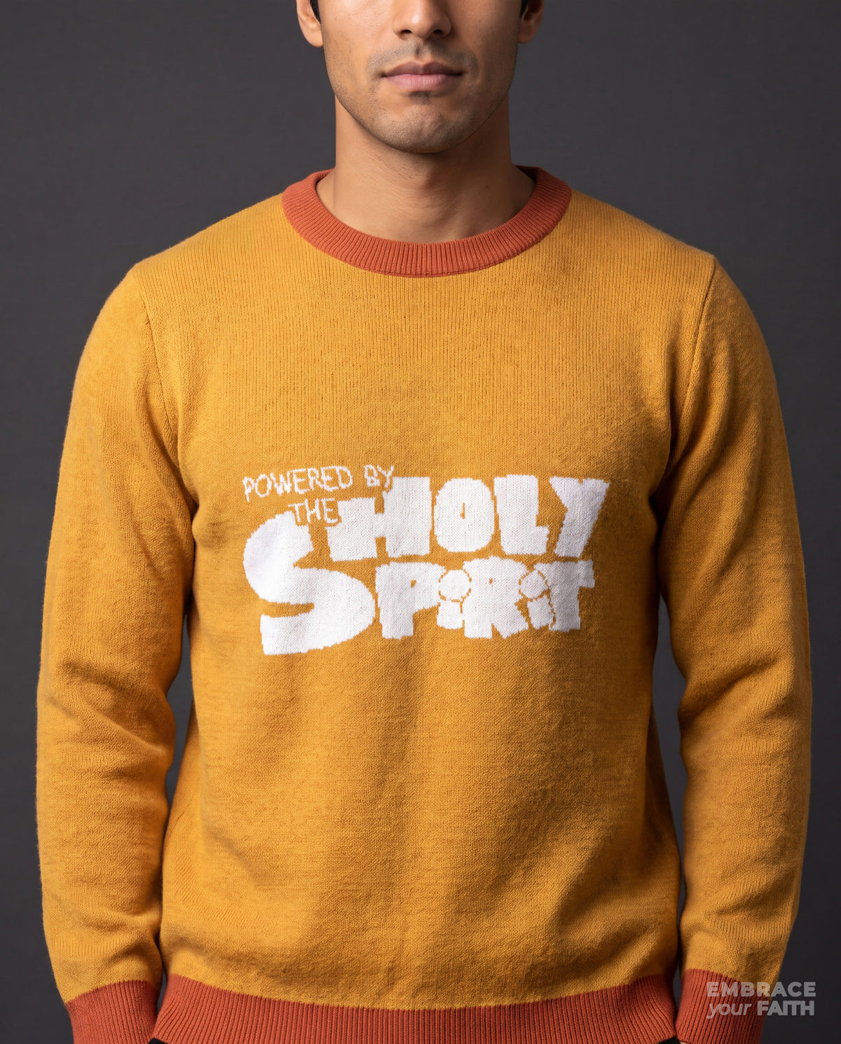 Close-up of the print on the Powered by The Holy Spirit Knitted Crew Neck Sweater in mustard yellow